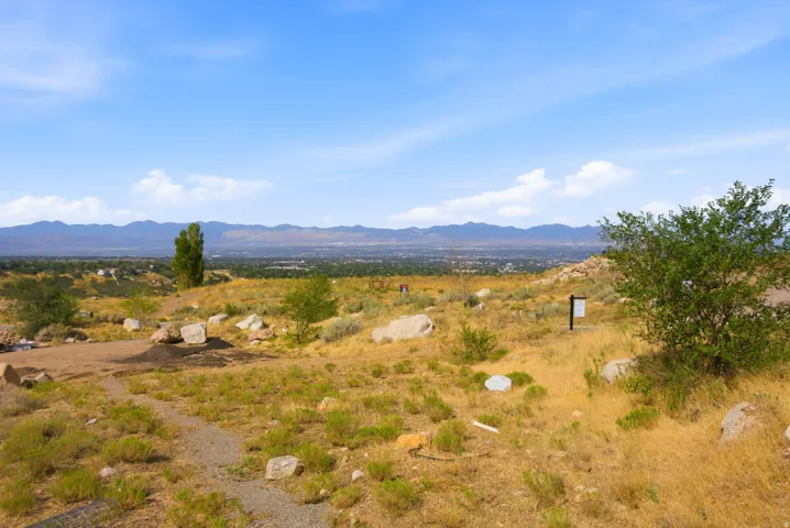Elevated terrain with distant mountain ranges and a city backdrop