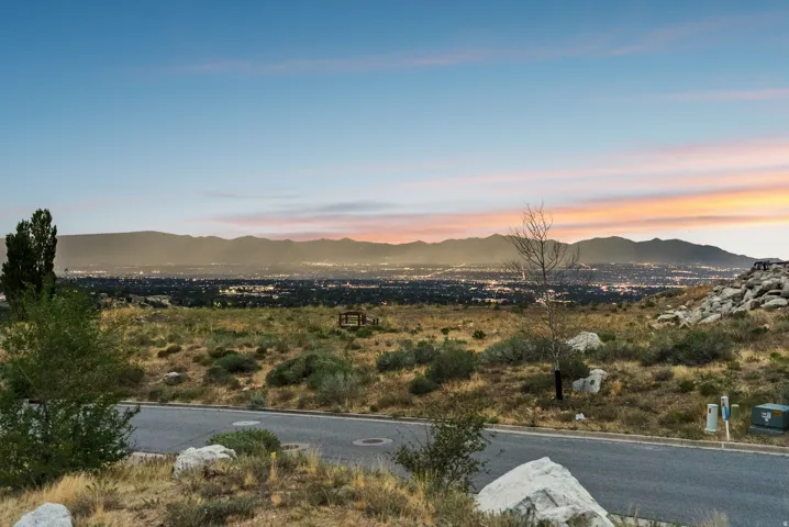 Expansive scenery featuring distant city lights and mountain ranges