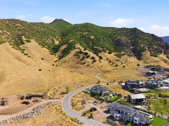 Mountainous terrain, hillside residences, curved roadways, and extensive undeveloped land
