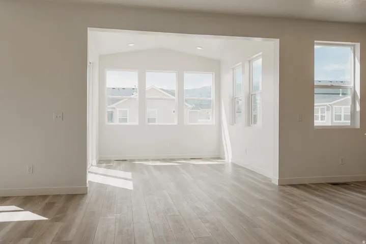 Wood-finish flooring throughout, bright white walls, and multiple windows