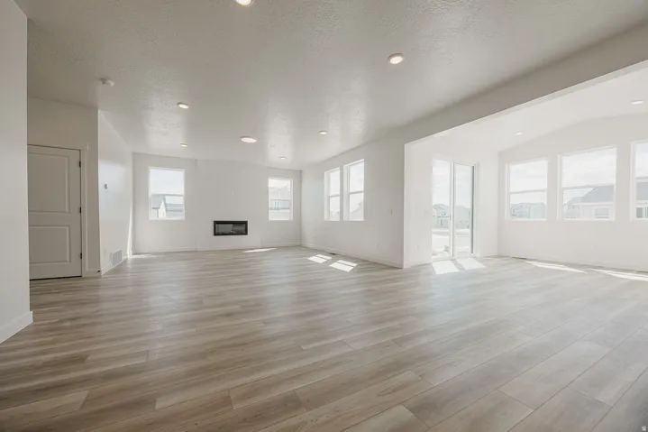Recessed lighting, light wood-finish flooring, built-in fireplace, and expansive windows