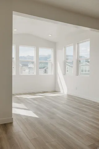Vaulted ceiling, recessed lighting, wood-finish flooring, multiple windows, mountain scenery