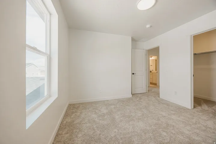 Neutral wall finishes, light-colored carpeting, and a double-pane window