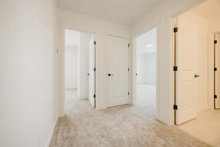 Light-toned carpet flooring throughout the hallway