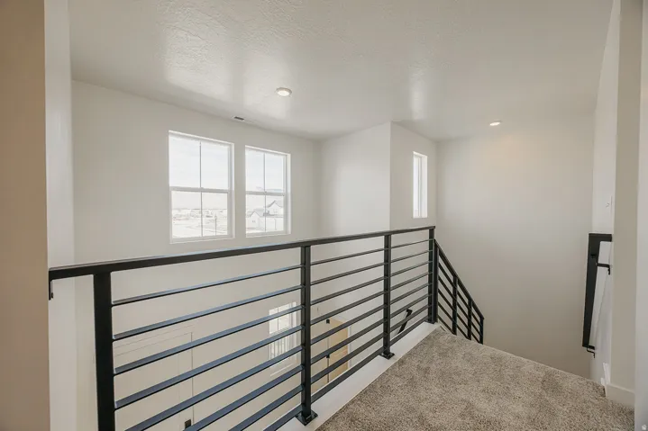 Modern horizontal bar railing system, recessed ceiling lighting, and multiple windows