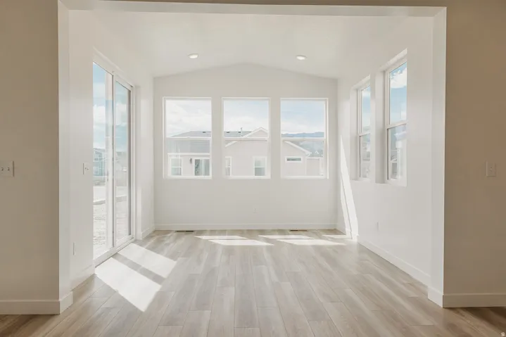 Vaulted ceiling, recessed lighting, wood-finish flooring, sliding glass door, multiple large windows
