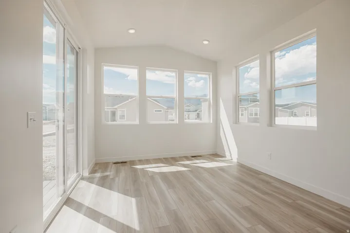 Bright interior space featuring wood-finish flooring, recessed lighting, and multiple windows