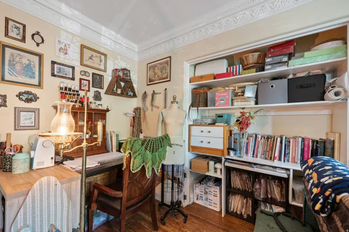 Hardwood flooring, crown molding, built-in shelving, desk area, and recessed storage