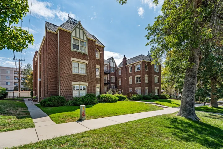 Brick exterior with multiple gables, a pitched roof, and mature perimeter trees