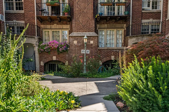 Brick exterior with arched window details, ground-level windows, and a classic outdoor lamp post