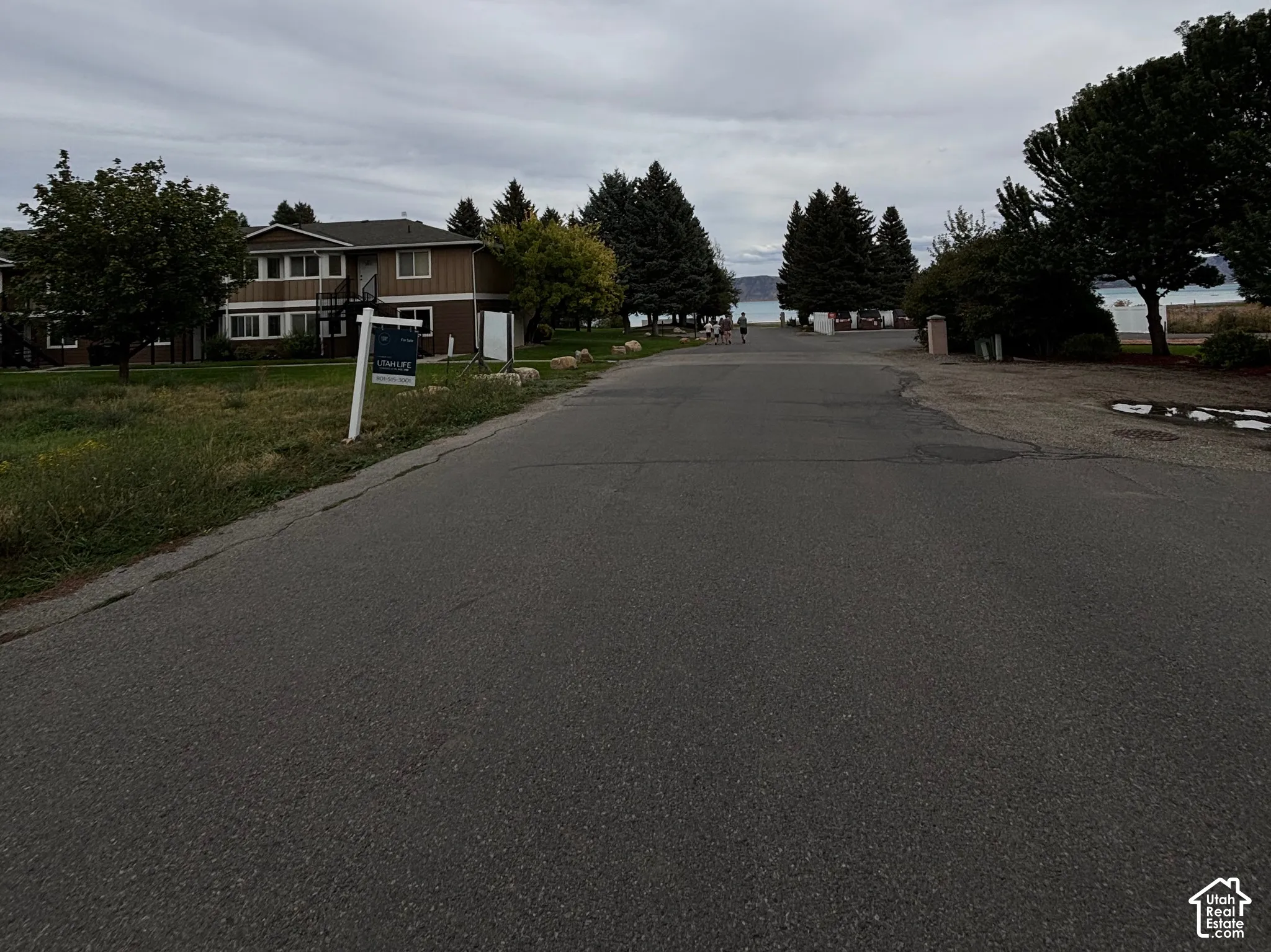 Road driving up to lot, with lake views across the street from the marina