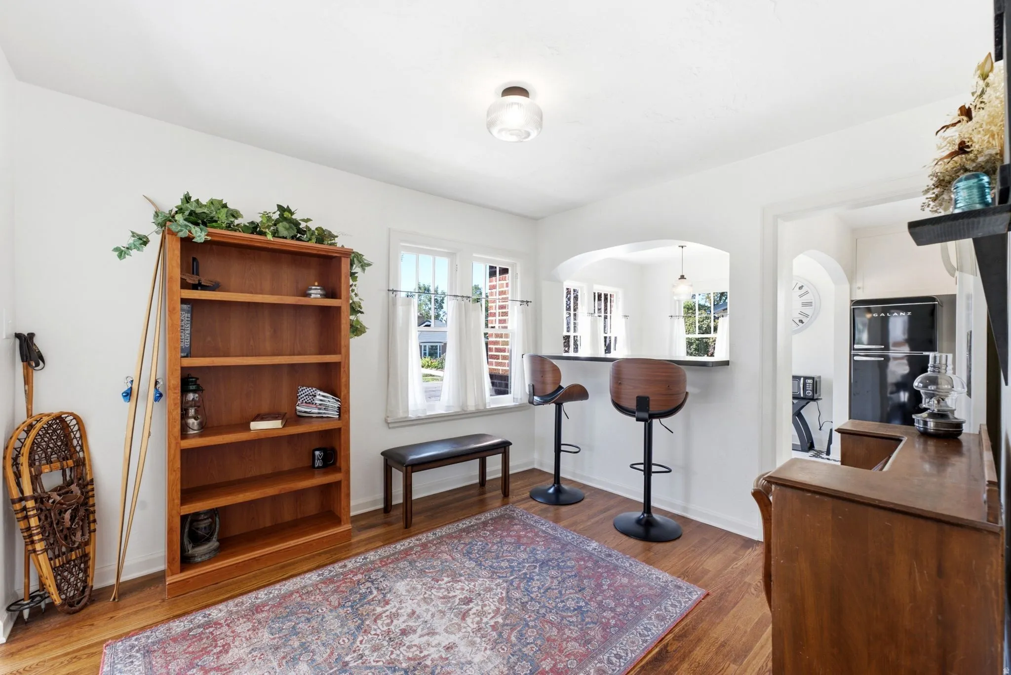 Hardwood flooring, arched pass-through, built-in breakfast bar, and multiple windows
