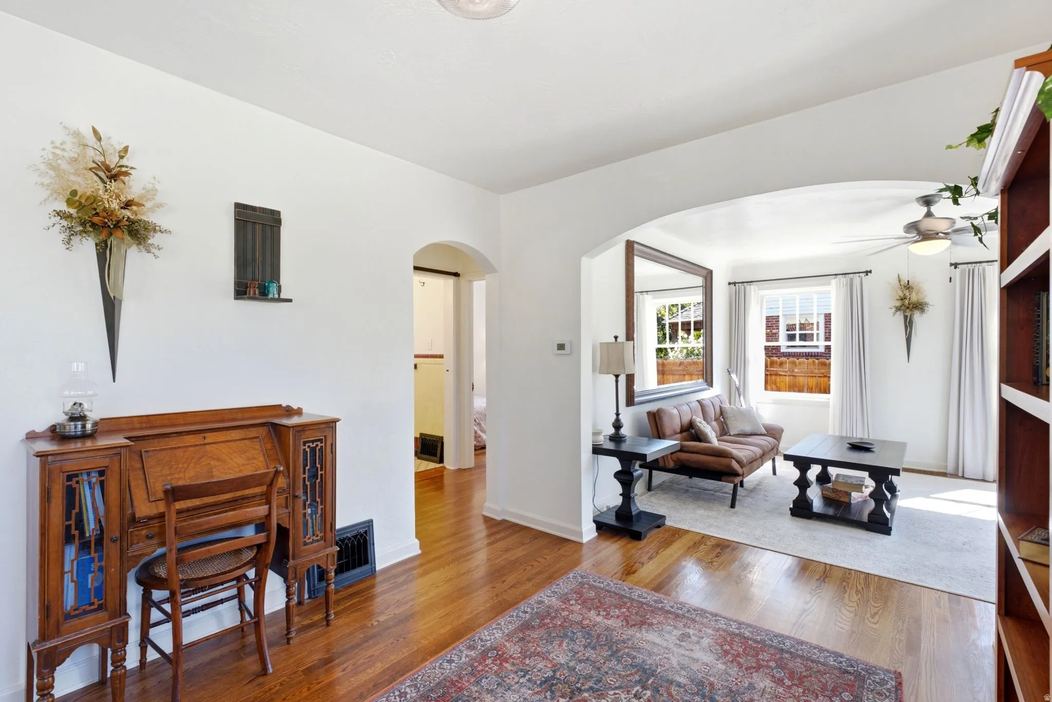 Hardwood-finish flooring throughout, arched doorway, recessed lighting, and built-in shelving