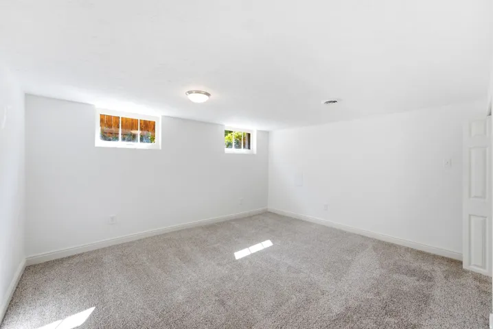Recessed windows, neutral wall finishes, flush mount ceiling fixture, and carpeted flooring