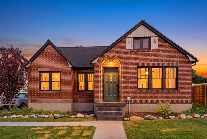 Brick exterior with a dark-pitched roof, arched entryway, and dark-framed windows