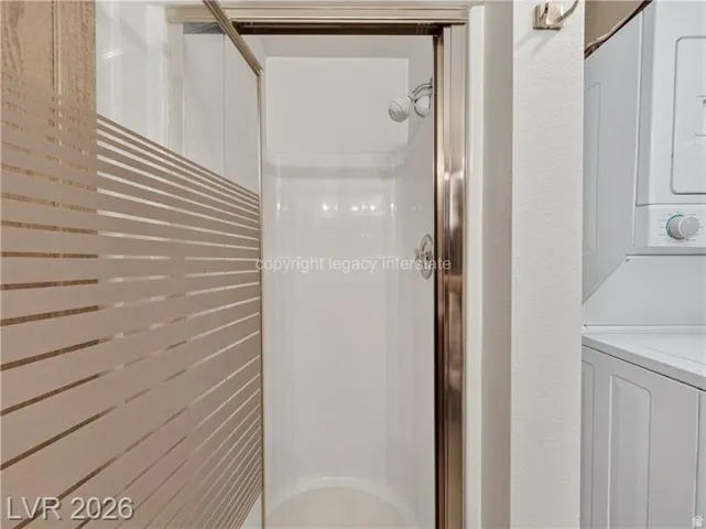 Fiberglass shower stall with a polished chrome frame, and a striped privacy screen