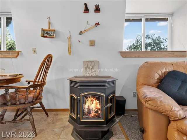 Cast iron wood-burning stove with a glass door, set on a tile floor