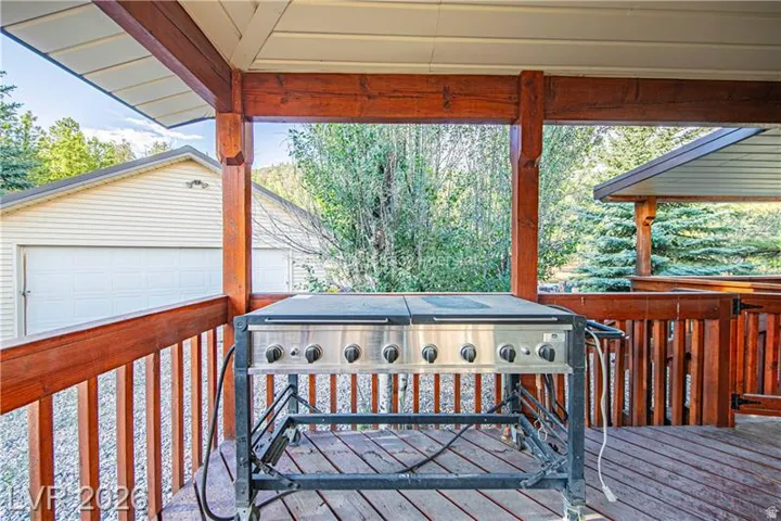 Wood deck featuring a covered patio with exposed beams and wood railings