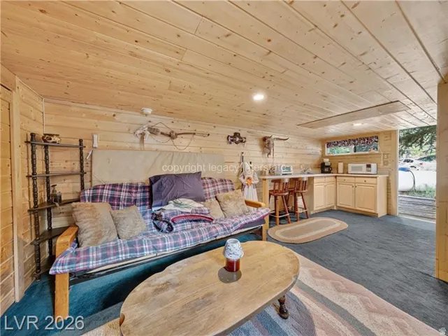 Wood-paneled walls and ceiling, recessed lighting, built-in kitchen cabinetry, and bar seating