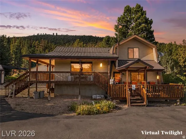 Multi-level wood deck with railings, an extended covered porch, a separate covered entry, and a metal roof