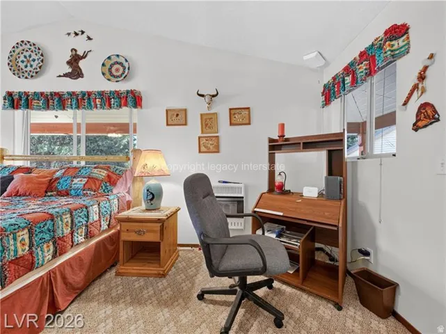 Sloped ceiling, dual windows, wood-finish desk, wood-finish nightstand, wall-to-wall carpeting