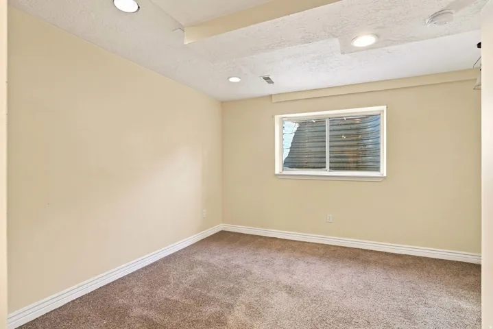 Recessed lighting, light-colored walls, window, white trim, and carpeted flooring