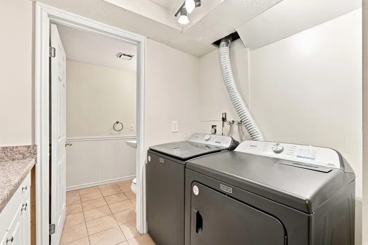 Laundry area featuring a utility sink, a light-colored countertop, and a built-in cabinet
