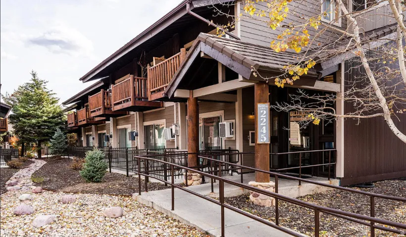 Multi-level exterior with wood balconies, a covered entry, and an accessible ramp