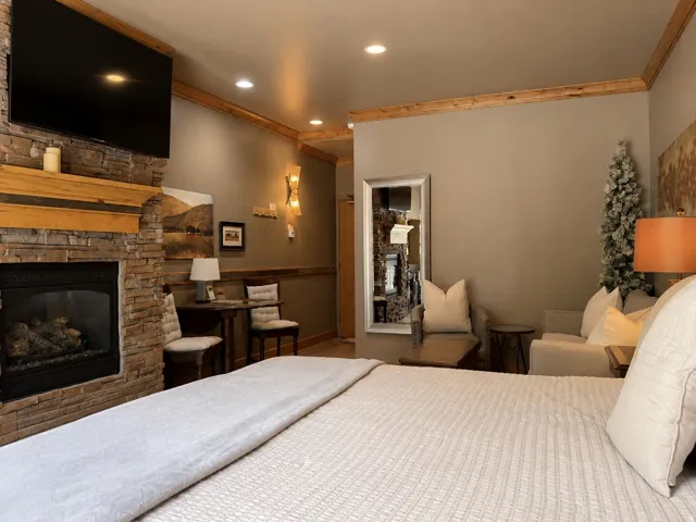 Stone-clad fireplace with a wood mantel, recessed lighting, wood trim details, and a built-in wall mirror