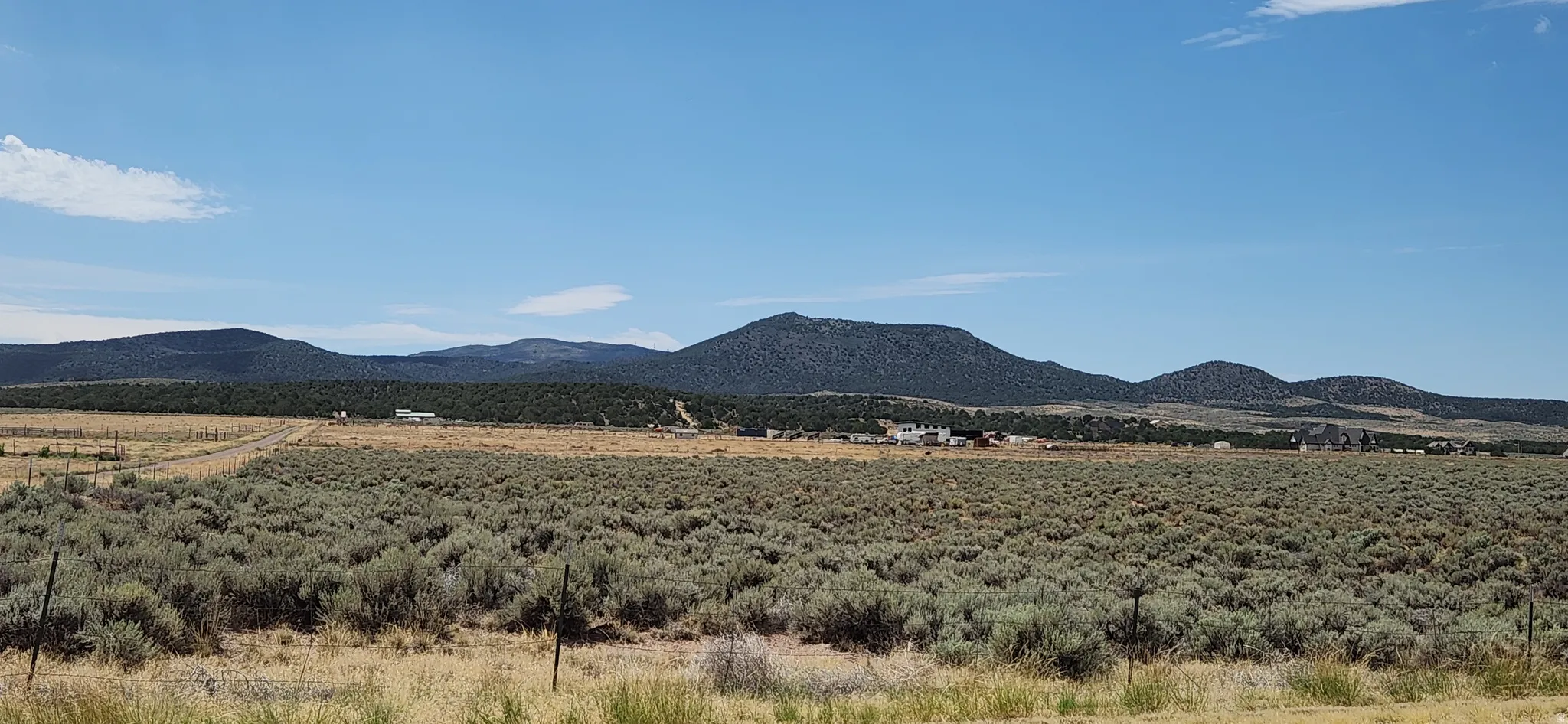 Expansive open terrain featuring natural vegetation and distant mountain ranges