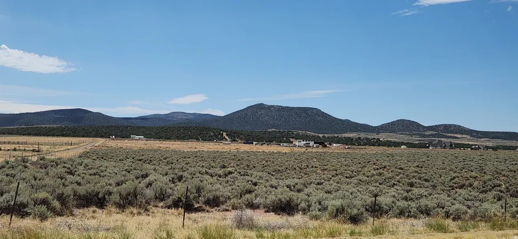 Expansive open terrain featuring natural vegetation and distant mountain ranges