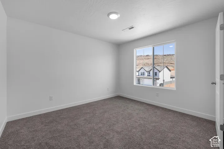 Recessed ceiling light, neutral wall paint, white trim, brown carpet flooring, and a window with mountain scenery