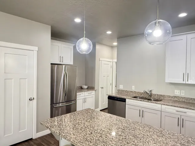 Kitchen featuring white shaker cabinetry, stainless steel appliances, speckled stone countertops, and recessed lighting