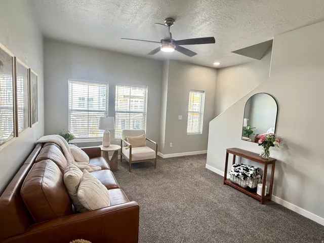 Vaulted ceiling with a flush-mounted ceiling fan, two large windows with blinds, recessed lighting, and a carpeted floor