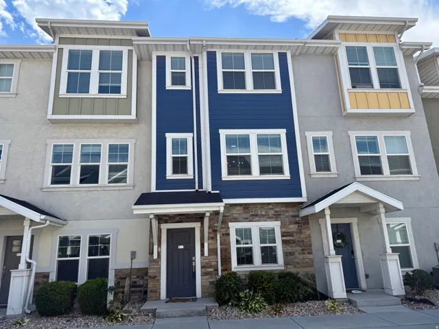 Modern townhouse exterior featuring stucco and siding with a stone veneer accent