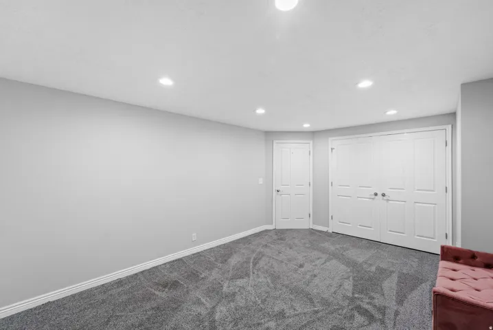 Recessed lighting, light gray wall finishes, gray carpet flooring, white paneled doors, and white trim