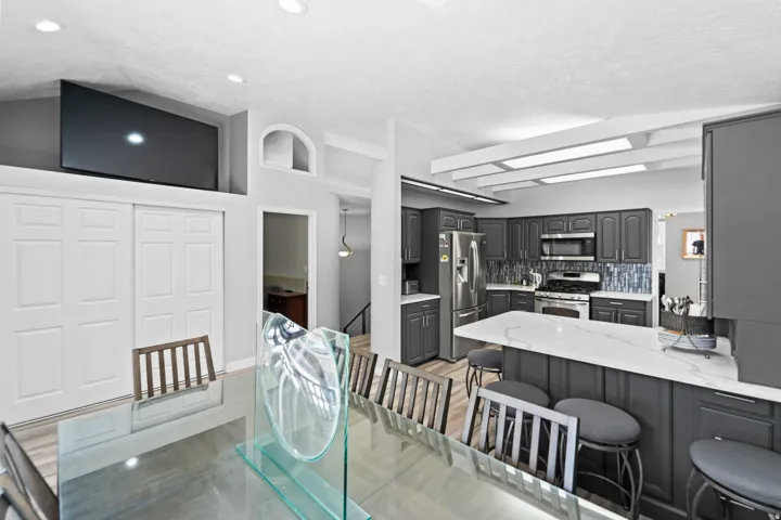 Kitchen featuring dark cabinetry, stainless steel appliances, white countertops, and a tiled backsplash
