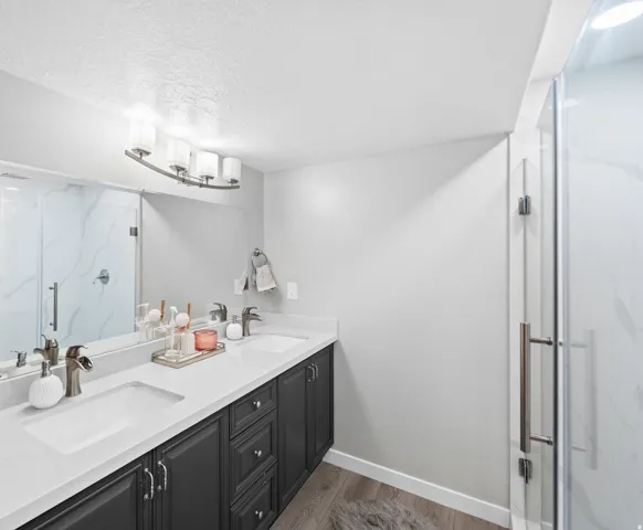 Dual vanity with integrated sinks, dark wood-finish cabinetry, and light-toned countertops