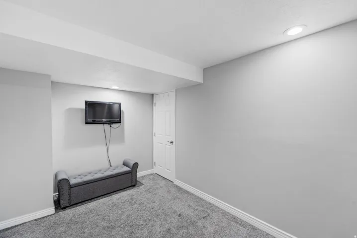 Recessed ceiling lighting, textured ceiling, light gray wall paint, white trim, and gray carpeting