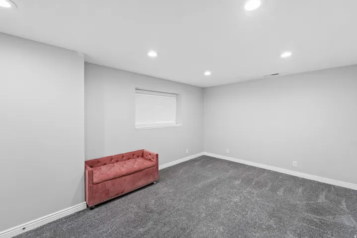 Recessed lighting, light gray wall finishes, window with blinds, and gray carpeting