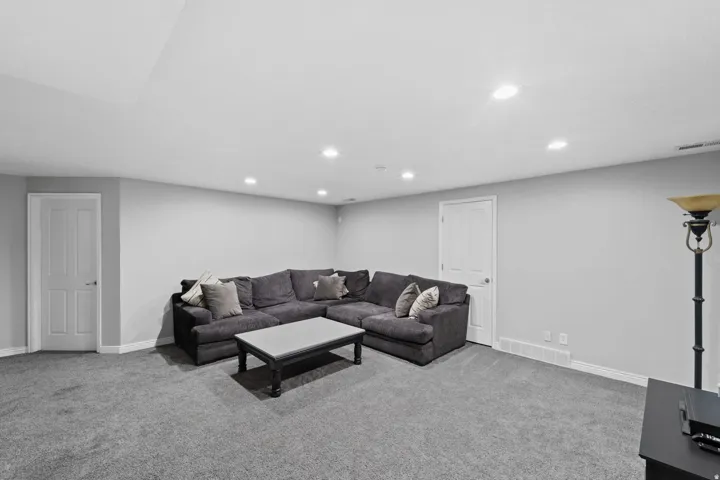 Recessed lighting, light gray walls, white trim, and two paneled doors