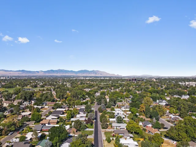 Expansive residential area featuring established homes, mature trees, and mountainous terrain in the distance
