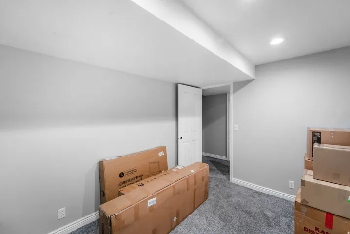 Recessed lighting, light gray wall paint, gray carpet flooring, white trim, and a white interior door