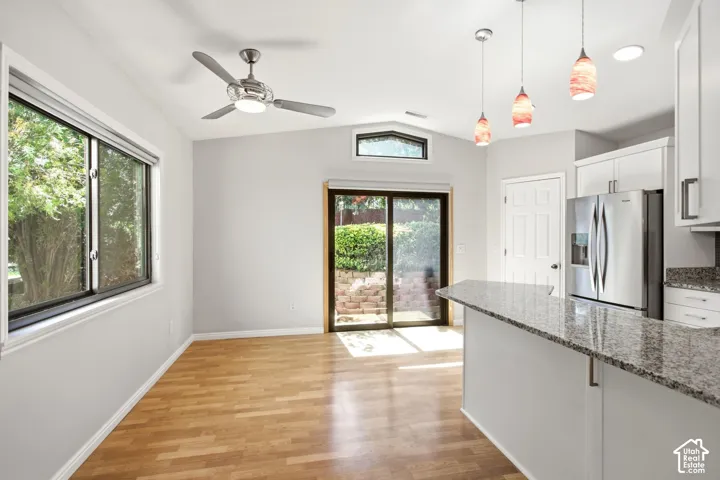 Wood-finish flooring, vaulted ceiling, and a ceiling fan