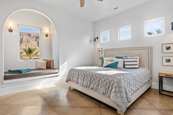 Arched window nook with built-in bench seating and sconce lighting