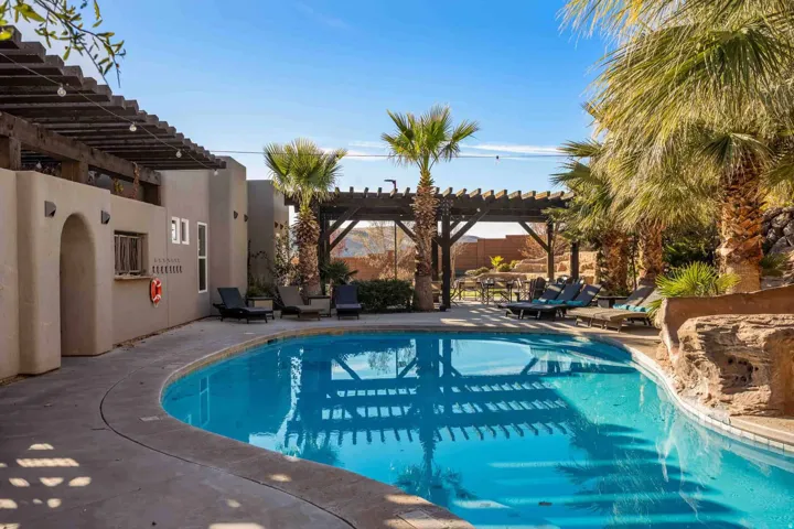Resort-style resort pool featuring crystal-clear water, curved perimeter decking, and integrated pergola structure
