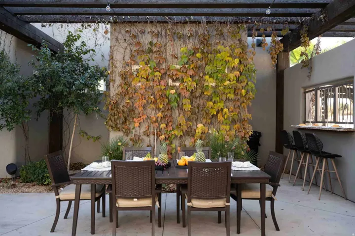 Outdoor patio with a wood pergola, integrated bar seating, and a built-in pass-through window