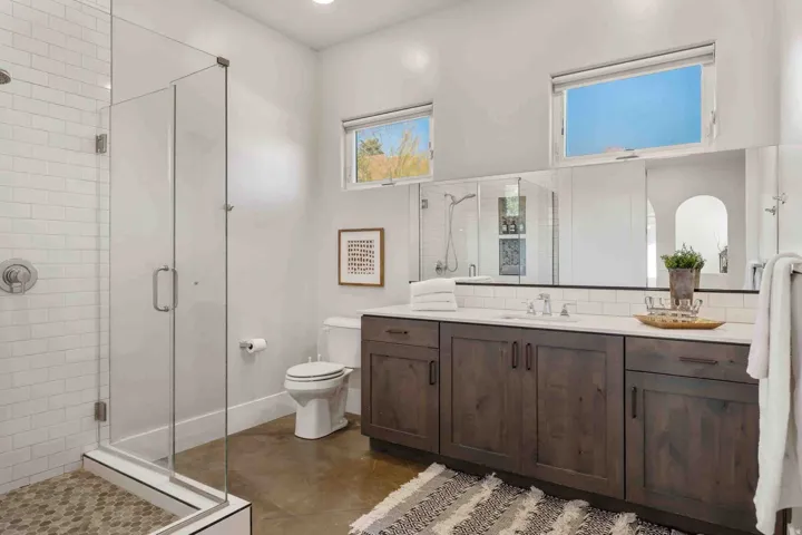 Glass-enclosed shower with subway tile surround and hexagonal mosaic floor