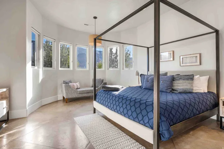 Curved wall with multiple windows, concrete flooring, and a contemporary pendant light fixture