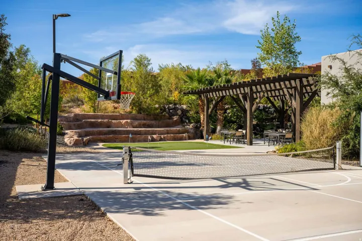 Multi-sport court, pergola-covered outdoor dining area, terraced landscaping, and integrated basketball hoop